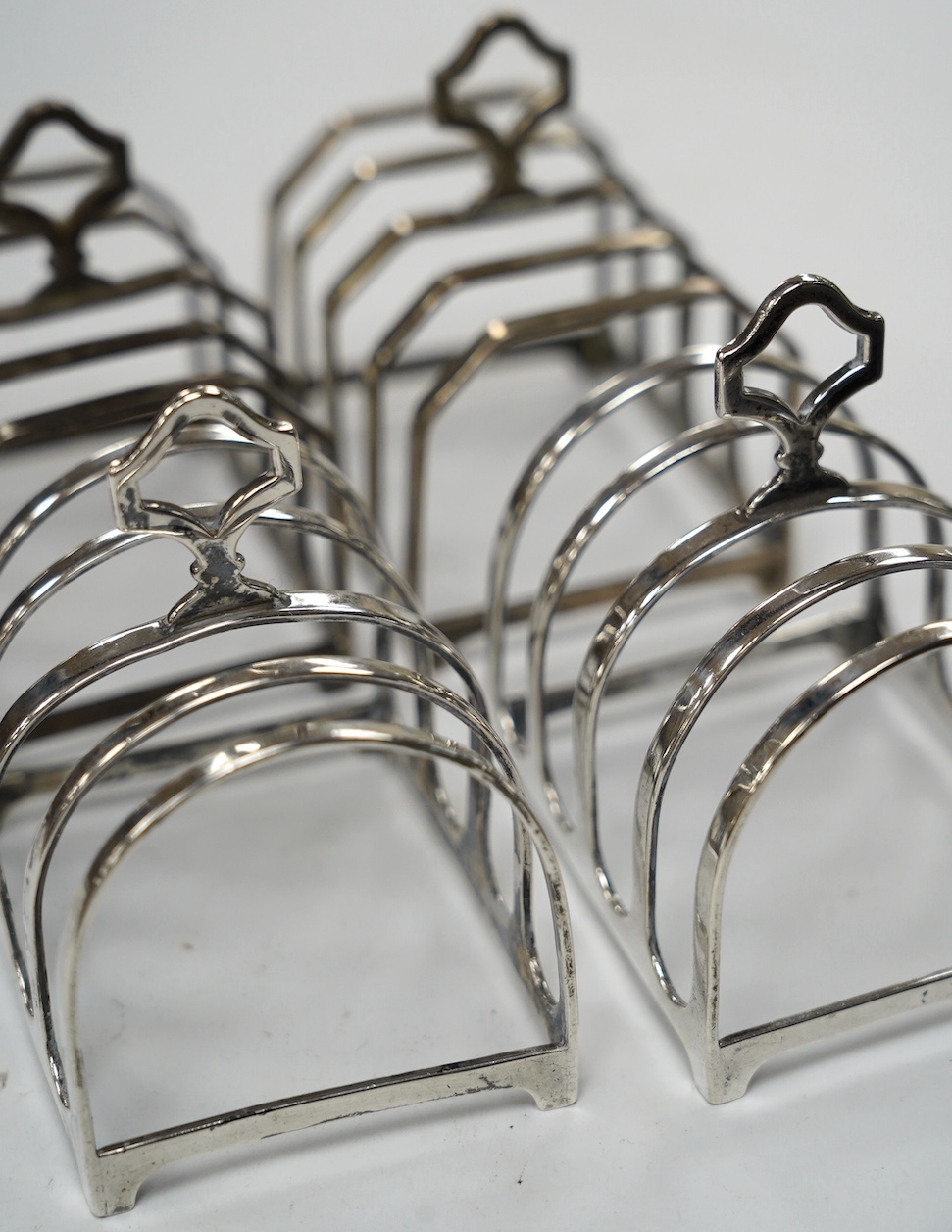 Two pairs of silver five bar toast racks, Birmingham, 1931 and Birmingham, 1932, 75mm, 10.7oz. Condition - fair